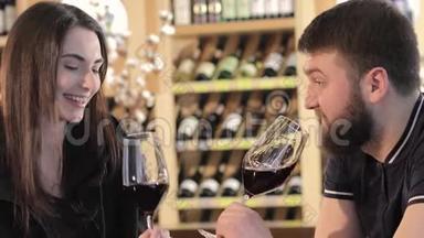一个女孩和一个餐馆里的男人交流并喝<strong>红酒</strong>，一对年轻夫妇在一张桌子上喝<strong>红酒</strong>。